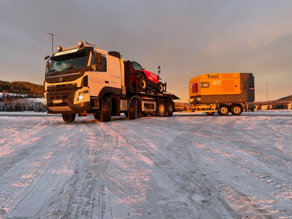 Hvit lastebil som står posert i solnedgangen