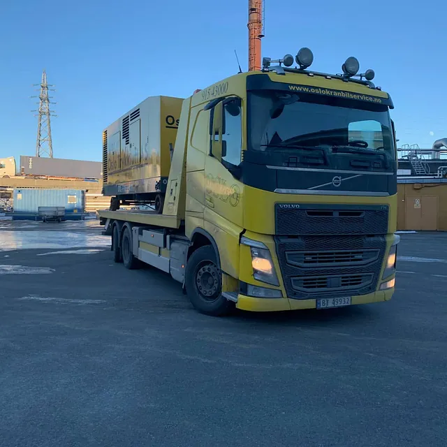 Gul lastebil driver med maskintransport